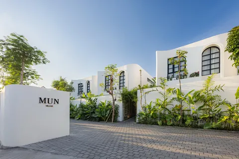 Mun Villas entrance sign with white villas and tropical planting