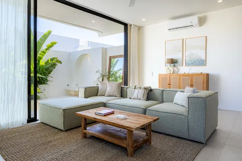 Living room with sage sofa, timber coffee table and sliding doors