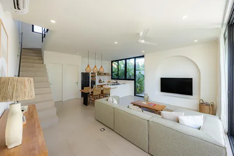 Living area with staircase, dining table and kitchen